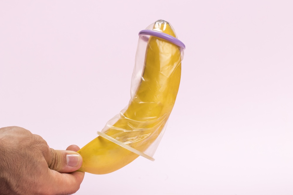 close-up-man-holding-banana-with-condom.jpg